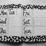 white and black weekly planner on gray surface