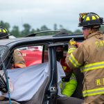 firefighters working around a crashed car