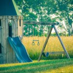 playground with wooden castle near green field