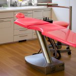 gray metal framed red dental treatment chair
