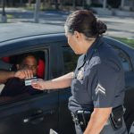 man giving his driver s license to the policewoman