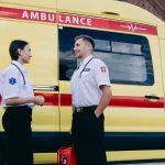 man and woman having conversation near an ambulance